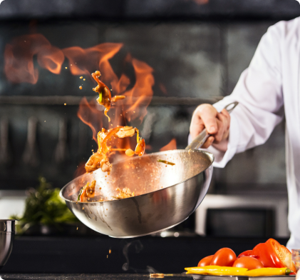 un chef cuisinier tenant une casserole contenant des aliments